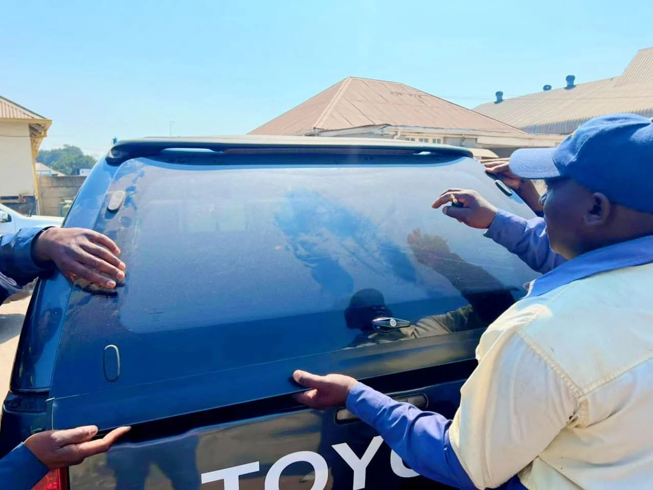 Technicians fitting a vehicle rear screen