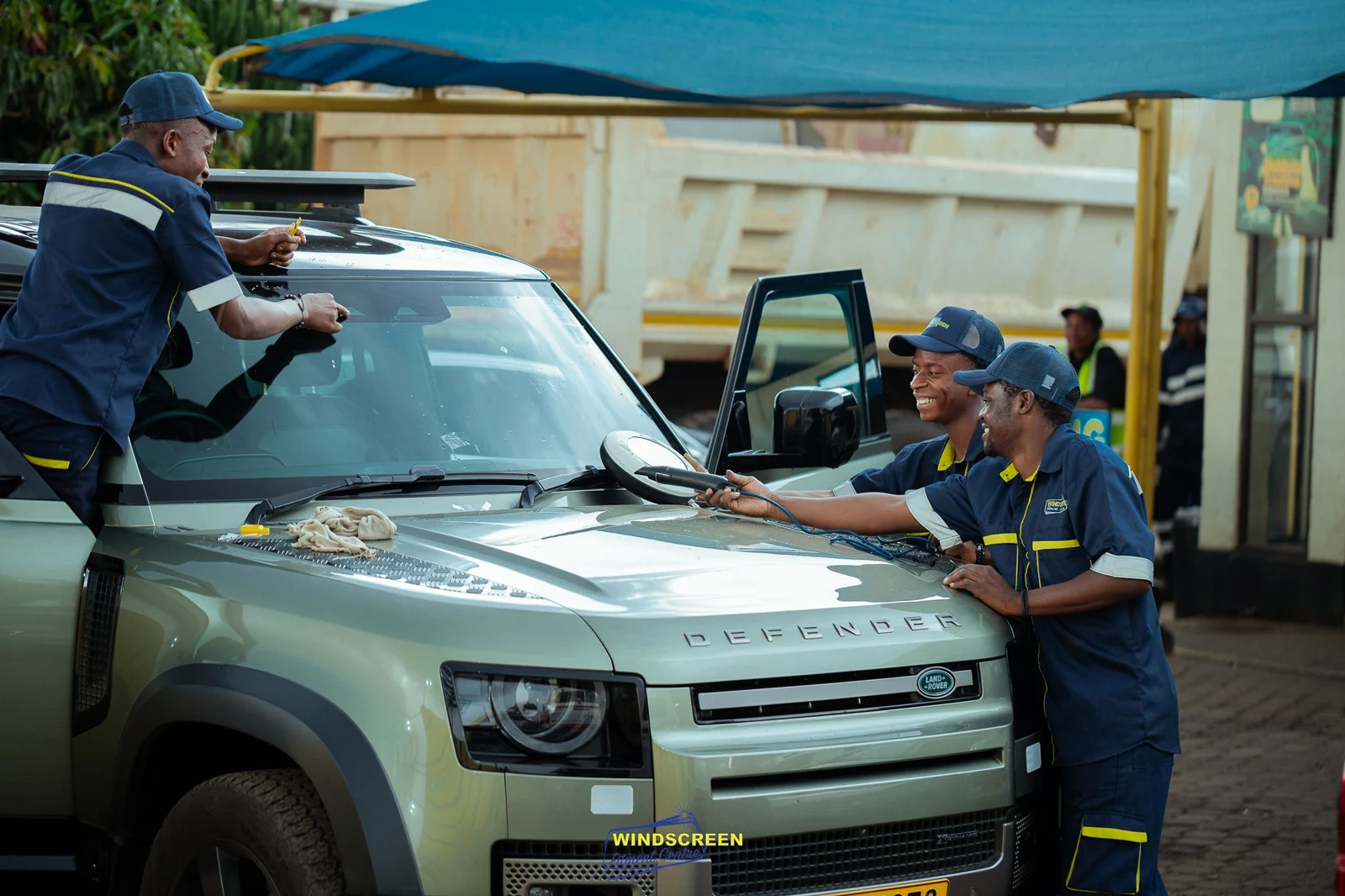 Technicians fitting a Land Rover Defender windscreen